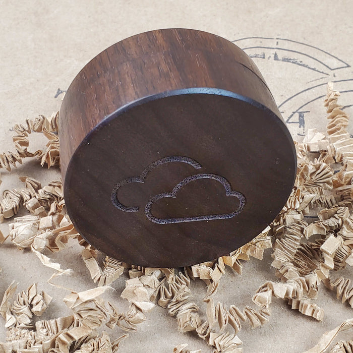 WALNUT WOOD HERB GRINDER WITH CLOUD LOGO ON CRINKLE PAPER AND THE 9TH CLOUD CANNABIS ACCESSORIES SHIP LOGO BACKGROUND
